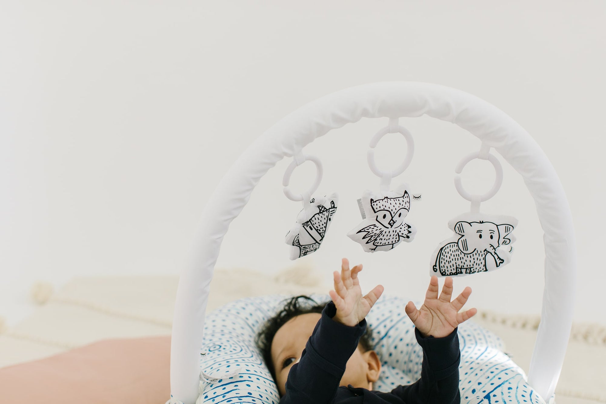 baby plays with sleepyhead toy arch